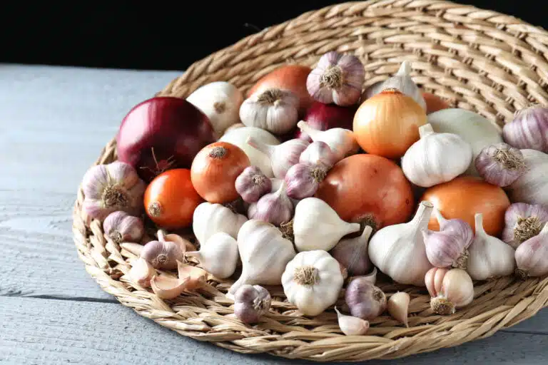 Ail et oignons crus frais dans un panier en osier conserver conservation