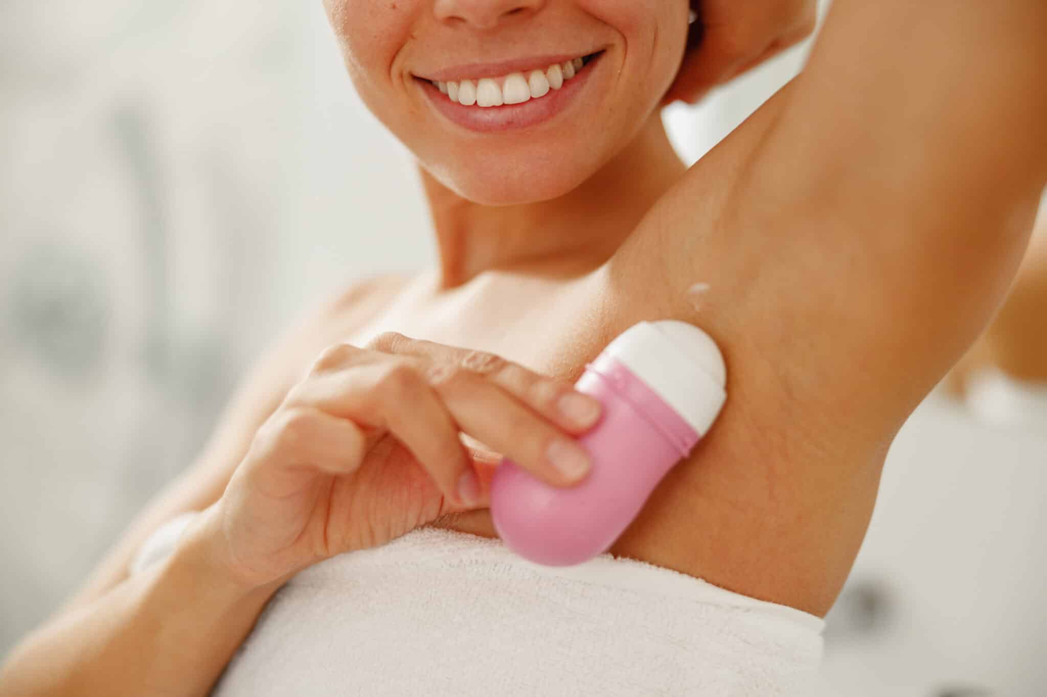 femme applique du d&eacute;odorant antitranspirant sur les aisselles