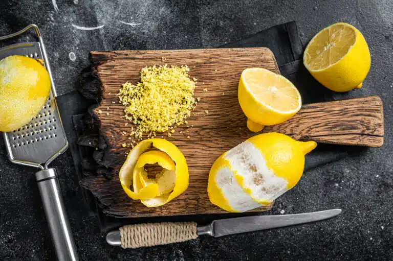 Zeste de citron r&acirc;p&eacute; et pelure en spirale sur planche de bois r&acirc;pe