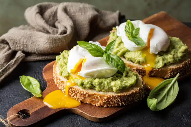 Tartine toast &agrave; l&rsquo;avocat &eacute;cras&eacute; avec &oelig;uf poch&eacute; &agrave; la coque avec jaune et feuilles de basilic &agrave; manger au petit-d&eacute;jeuner