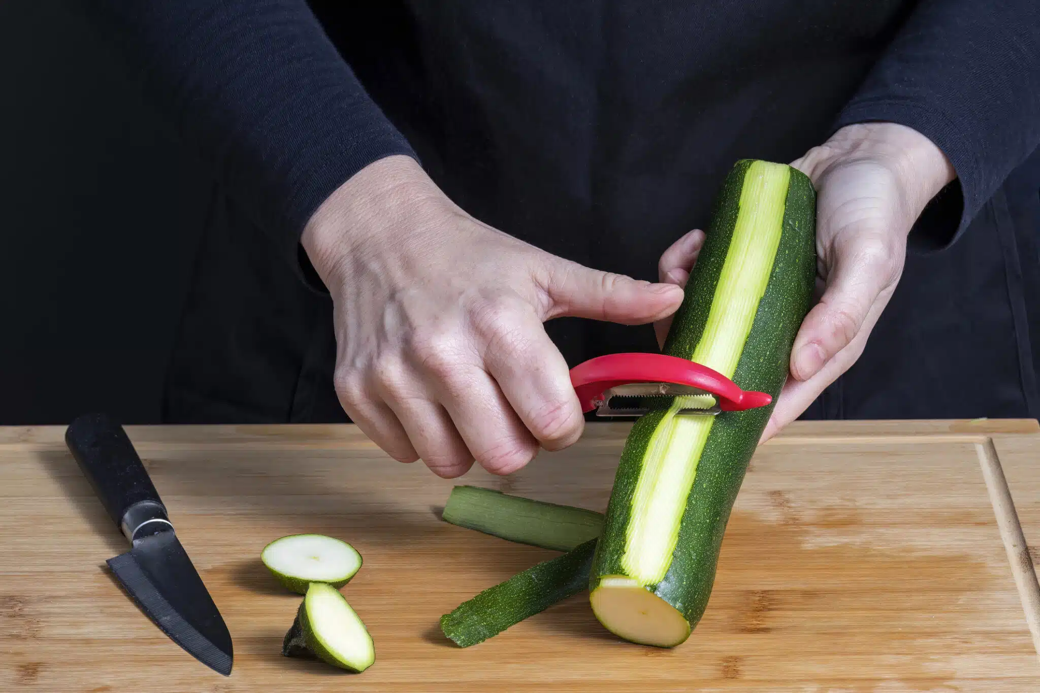 Peler les courgettes vertes fra&icirc;ches avec un &eacute;conome &eacute;plucher peau pelure &eacute;pluchure