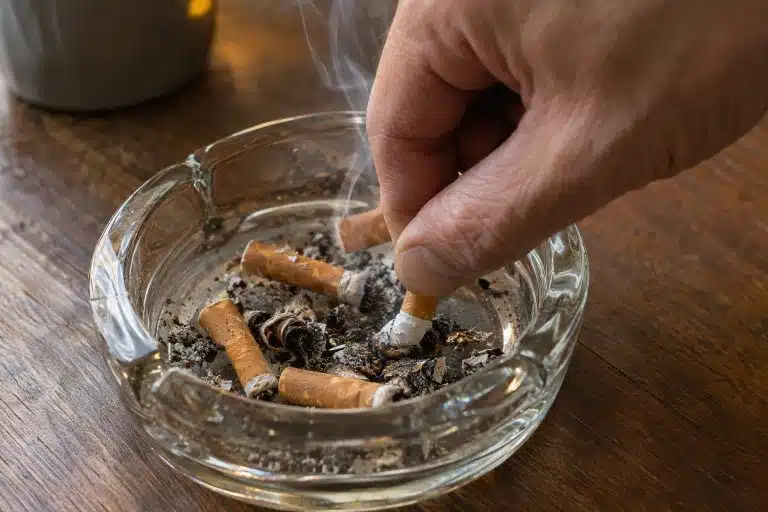 Personne en train d'&eacute;craser une cigarette dans un cendrier, geste de sevrage tabagique